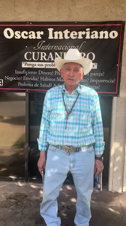 Oscar Interiano de pie frente al letrero de su consultorio